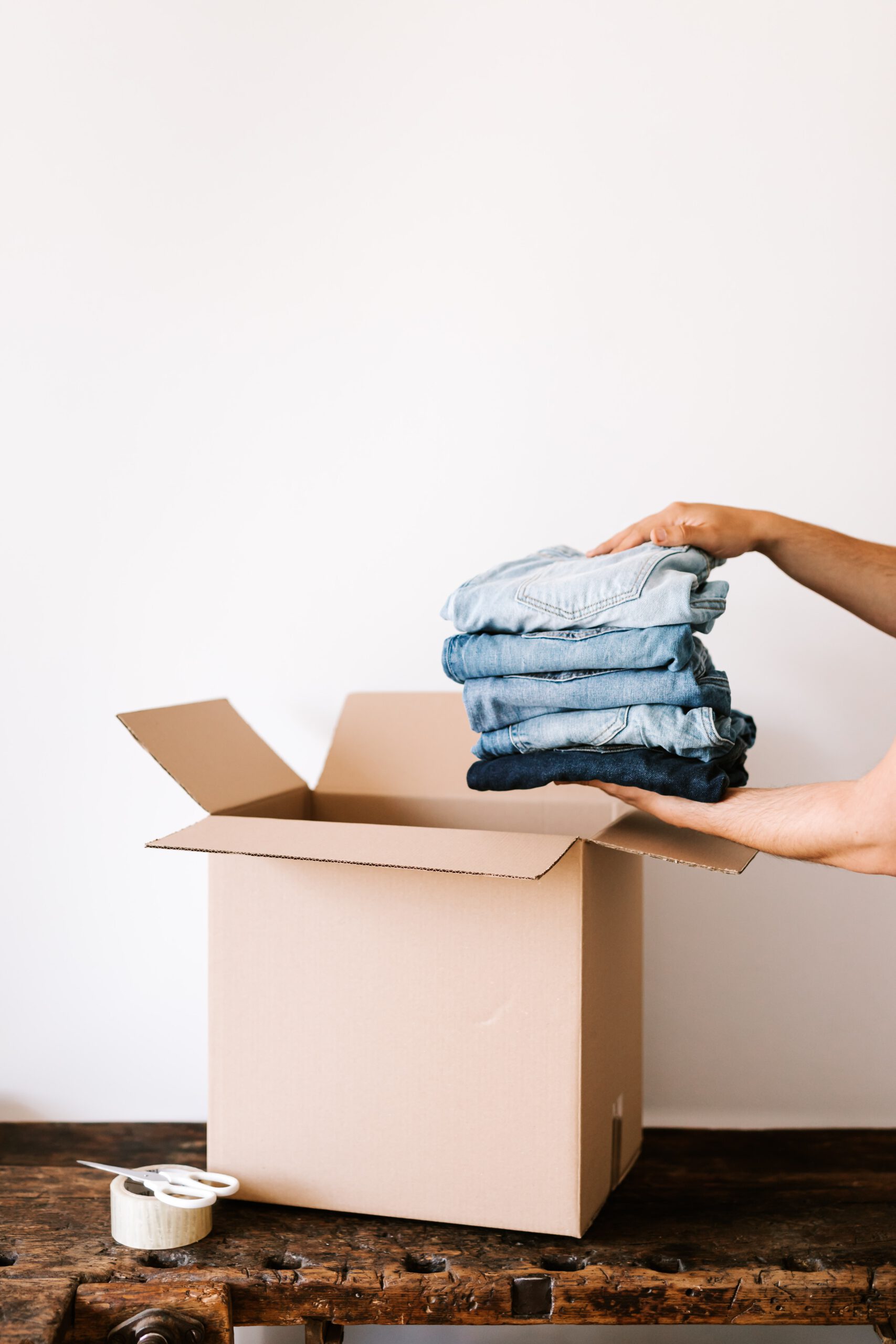 putting stack of jeans in box